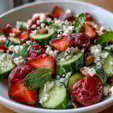 Crisp cucumber and strawberry salad with mint, a refreshing spring dish bursting with vibrant colors and fresh flavors.