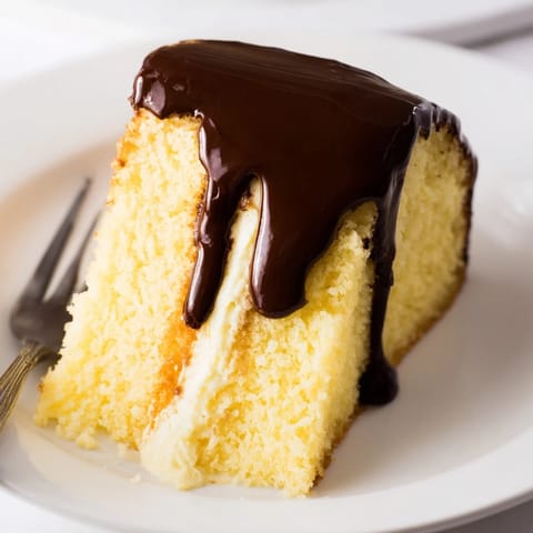 A perfect slice of Ho Ho Cake showcasing its fluffy cream and decadent chocolate topping, delicious!