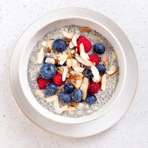 Poppy Seed Chia Pudding in a rustic bowl, featuring a creamy texture and a sprinkle of coconut.