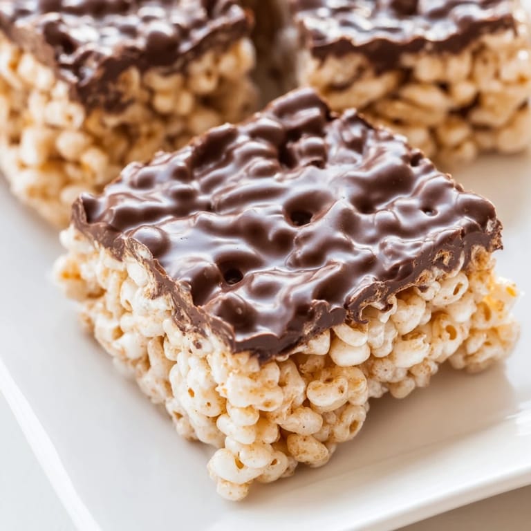 A close-up of golden brown Rice Krispie Treats, showing their crispy texture and delicious marshmallow.