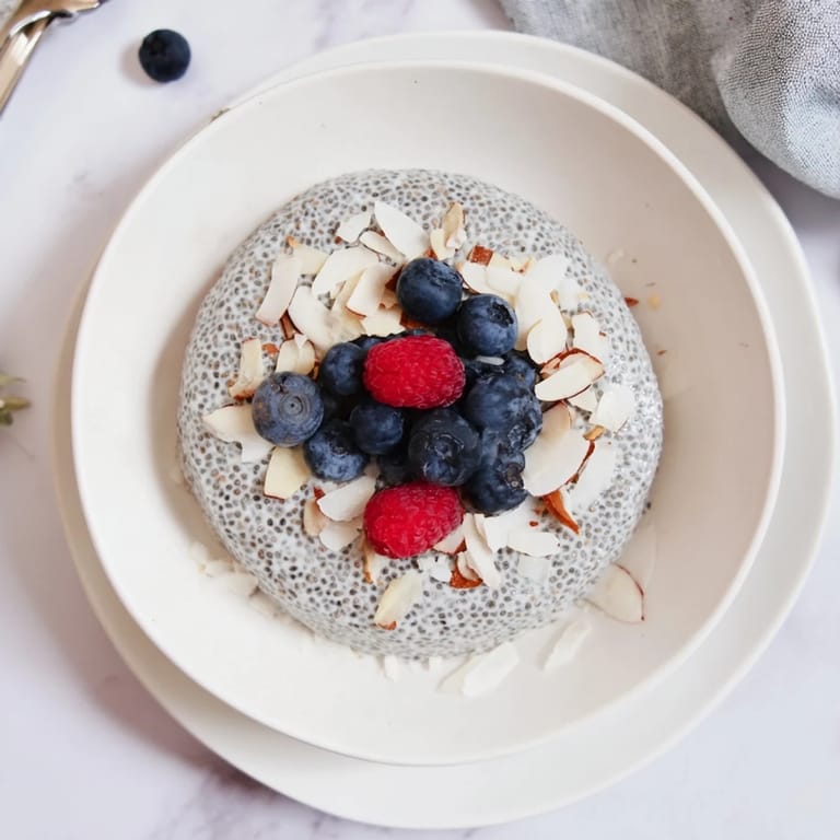 A close-up of Poppy Seed Chia Pudding layered with blueberries and sliced almonds, perfect for breakfast.
