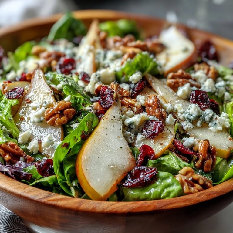 Deliciously plated Pear Gorgonzola Salad with glistening honey-balsamic dressing, dotted with dried cranberries and crumbled cheese, perfect for a vegetarian and gluten-free lunch or dinner.
