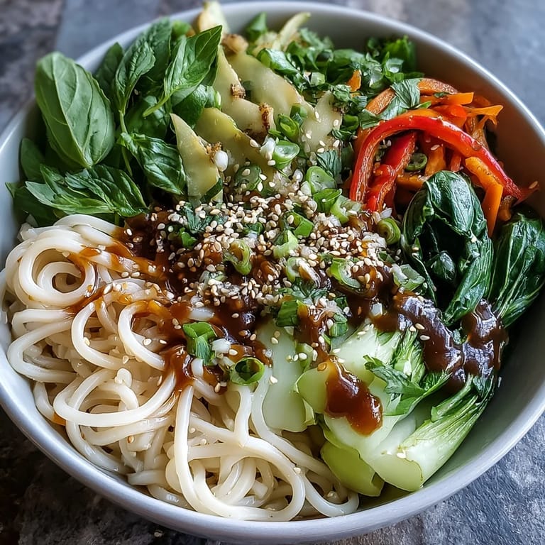 Gluten-free shirataki noodle bowl topped with toasted sesame seeds and fresh herbs, perfect for a quick vegan dinner.