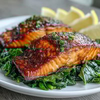 Golden-brown, extra-crisp Air Fryer Salmon and Swiss Chard plated with fresh lemon wedges and sautéed greens.