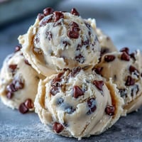A close-up of creamy Greek Yogurt Cookie Dough scoops studded with mini chocolate chips, ready to eat chilled.